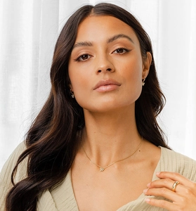 Close-up of elegant gold butterfly necklace and matching earrings worn by a model