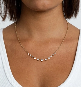Détail du collier doré avec onze zircons ronds disposés en courbe sur le mannequin