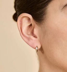 Détail de la boucle d'oreille créole en argent S925 doré sertie de trois zircons brillants