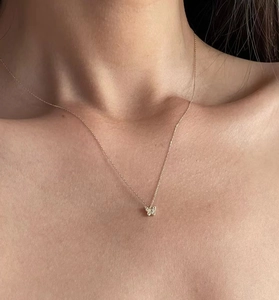 Close-up of a sparkling silver butterfly pendant necklace worn on a model's neck