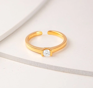 Macro shot of an adjustable gold ring with a sparkling solitaire round zircon stone