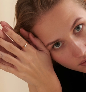 Close-up of minimalist gold S925 silver ring featuring a single sparkling round solitaire