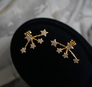 Macro detail of star-shaped earrings in gold finish with sparkling cubic zirconia