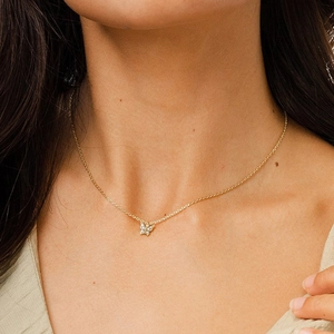 Elegant gold butterfly pendant necklace with sparkling zircons worn by a model