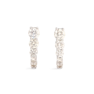 Détail des boucles d'oreilles en U argentées avec sertissage vertical de zircons