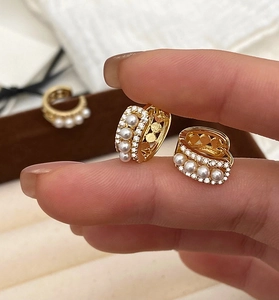 Détail de boucles d'oreilles créoles en argent S925 doré avec perles et zircons
