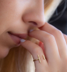 Gros plan d'une bague ouverte en T en argent S925 doré au style minimaliste au doigt