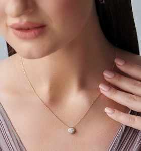 Macro shot of s925 silver gold-plated necklace with a sparkling pavé zircon round pendant