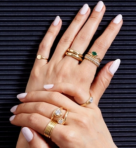 Detailed view of stacked gold S925 silver rings with emerald gems and zircon wheat pattern