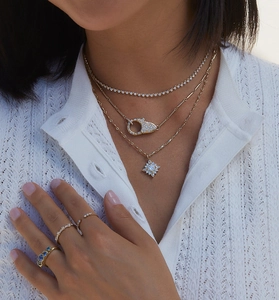 Close-up of layered 18K gold necklaces with star pendant and sparkling zircon accents
