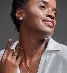 Detailed view of layered S925 sterling silver necklaces and round zircon stud earrings