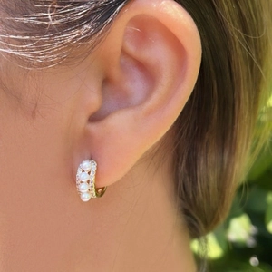 Élégantes créoles dorées avec quatre perles et incrustation de zircon sur l'oreille