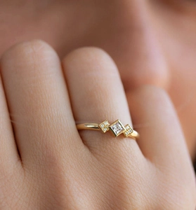 Vue macro d'une bague en argent S925 dorée avec une pierre centrale de taille princesse