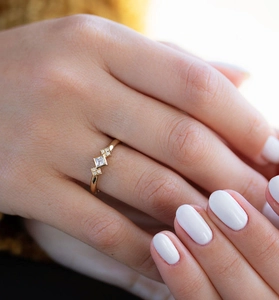 Gros plan sur une bague minimaliste en argent S925 avec une pierre carrée centrale