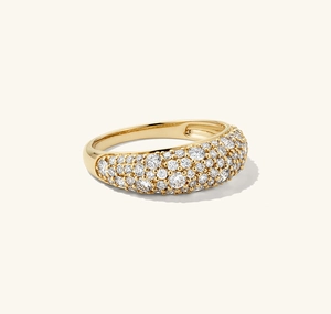 Macro shot of gold pave dome ring with brilliant clear stones on neutral background