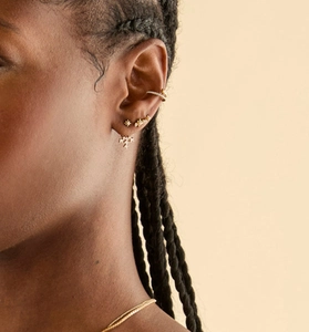 Detail of gold ear cuff and star stud set with micro-pave cubic zirconia on model