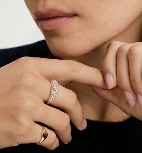 Detail of a wide domed silver ring paved with shimmering cubic zirconia on model's finger