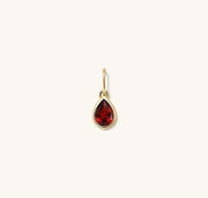 Close-up of S925 silver teardrop pendant with a deep red pear-cut gemstone in gold