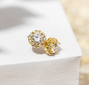 Macro shot of gold-plated silver halo stud earring with central brilliant-cut cubic zirconia