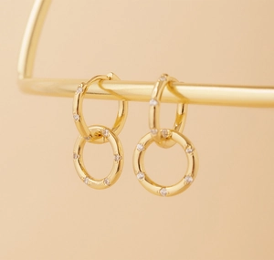 Detail of gold interlocking S925 silver hoop earrings with micro-pave zircon stones