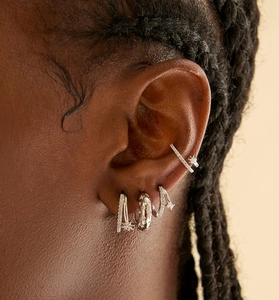 Detail of S925 silver ear cuff and huggie earrings with zircon star charms on ear