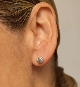 Macro shot of halo silver stud earring with round cubic zirconia on a model ear