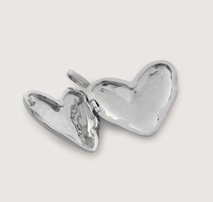 Detail shot of an open silver heart-shaped locket pendant showing the inner compartment