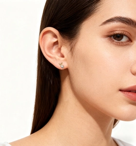 Close-up of minimalist S925 silver deer stud earrings in two-tone gold on a female model