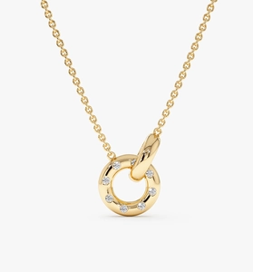 Macro detail of intertwined gold double rings pendant with sparkling crystal inlay