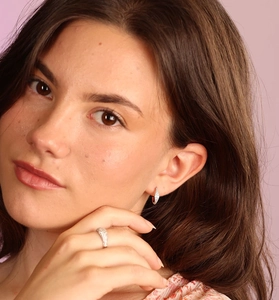 Detail showing S925 sterling silver huggie earrings and a wide band diamond ring on model