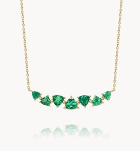 Detailed close-up of seven triangular green zircons set in a gold S925 silver necklace
