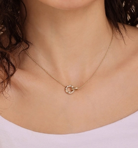 Close-up of a double interlocking gold ring pendant necklace worn by a female model