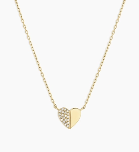 Detail of a gold heart puzzle necklace with sparkling pavé diamonds and a polished finish
