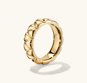 Detail eines breiten Goldrings mit elegantem Plissee-Muster und poliertem Finish