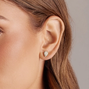 Elegant gold pear cut drop stud earrings with sparkling halo zircon on a model's ear