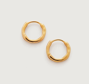 Macro detail of gold hoop earrings featuring irregular organic texture and hinge clasp