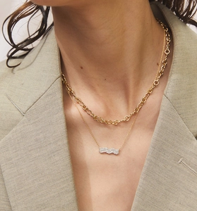 Détail de colliers superposés en argent S925 doré avec pendentif ondulé serti pavé