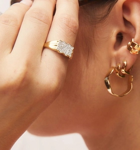 Close-up of elegant S925 silver gold-plated ring and earrings set with zircon stones
