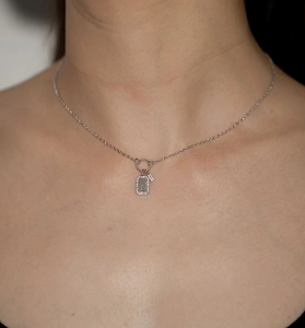 Close-up of S925 sterling silver necklace with a sparkling diamond pendant on a model neck
