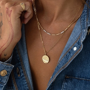 Layered gold S925 sterling silver necklaces with star moon pendant on denim background