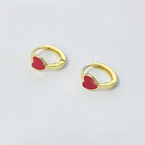 Detailed view of gold hoop earrings with red enamel heart charms in a sweet style