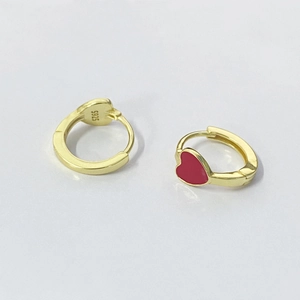 Macro view showing S925 sterling silver hallmark on gold-plated red heart huggie earrings