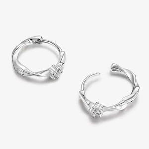 Macro detail of S925 sterling silver Mobius earrings with round cubic zirconia stones