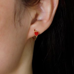 Golden S925 silver hoop earrings with red heart enamel pendant shown on model ear