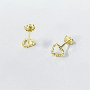 Vue macro du poinçon S925 sur des boucles d'oreilles cœur évidé en argent doré