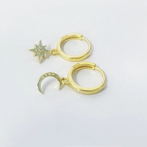 Detail shot of gold S925 sterling silver hoop earrings with star and moon pendants
