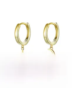 Detail of S925 sterling silver earrings with zircon star and moon pendants in gold finish