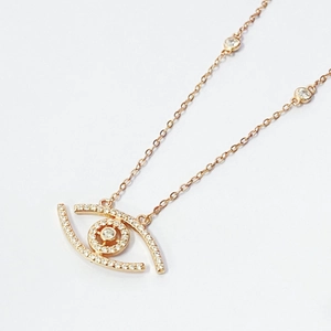 Detail view of rose gold Evil Eye pendant with pavé white zircons on white paper