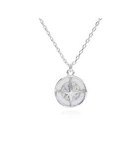 Detailed close-up of S925 sterling silver compass pendant with star relief and engraved letters