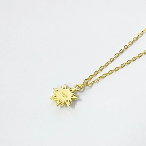 Detailed close-up of S925 hallmark on the gold sunburst pendant necklace backing